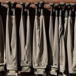 Photo- Chest-high boots called waders hang from the A Bar A ranch's fish shack, puckishly called the Liars' Lair, fishers are prone to exaggerating the size of fish caught 1 16in x 24in
