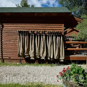 Photo- Chest-high boots called waders hang from the A Bar A ranch's fish shack, puckishly called the Liars' Lair, fishers are prone to exaggerating the size of fish caught 2 20in x 16in